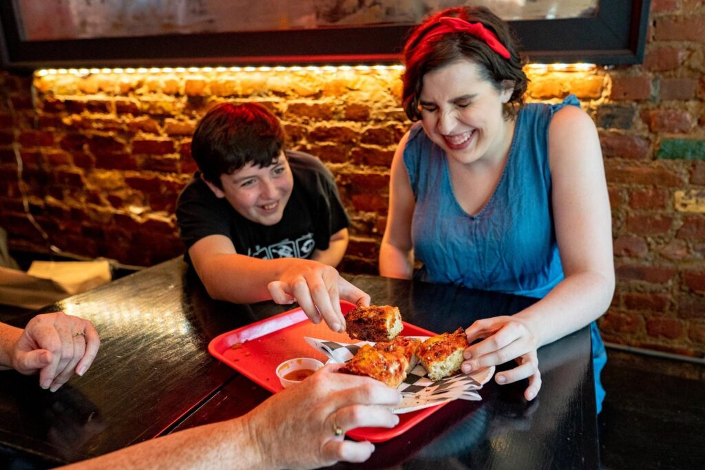 Guide sharing tastings with guests on a Greenwich Village food tour in New York