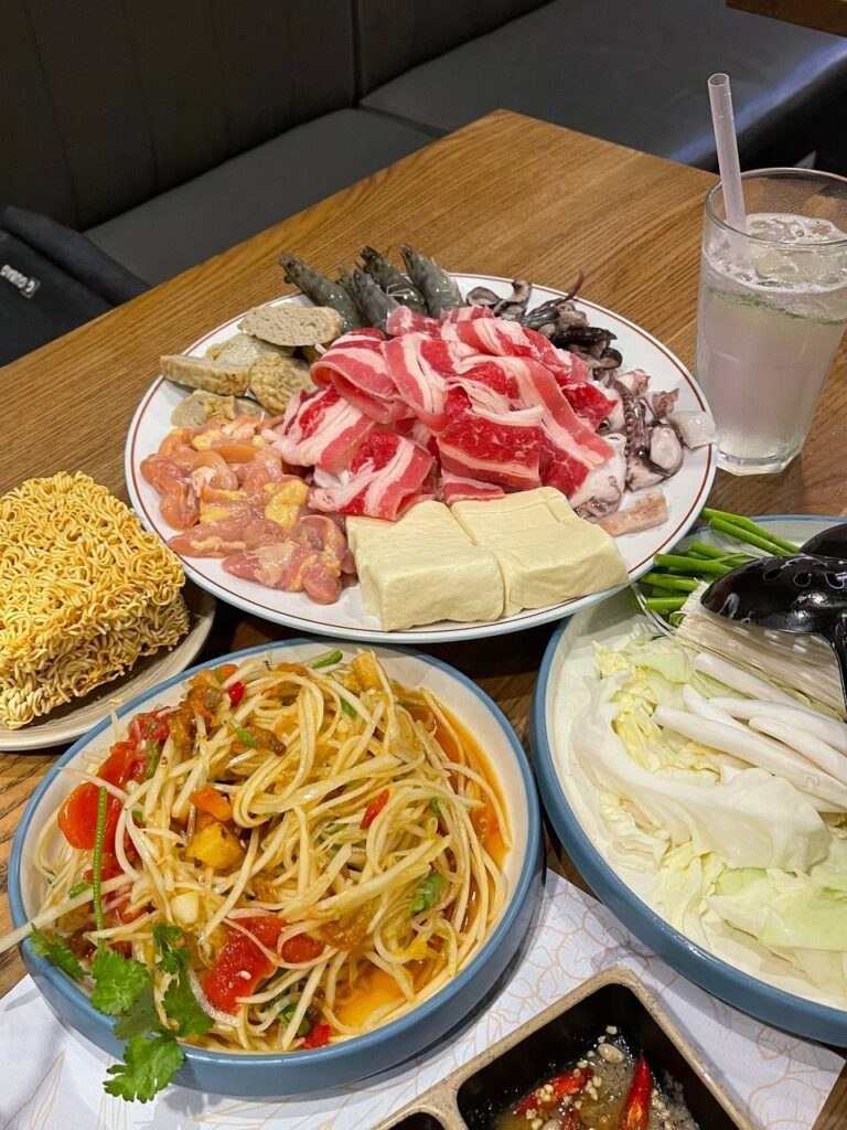 Colorful hot pot buffet spread of raw meats, seafood and vegetables in Boston