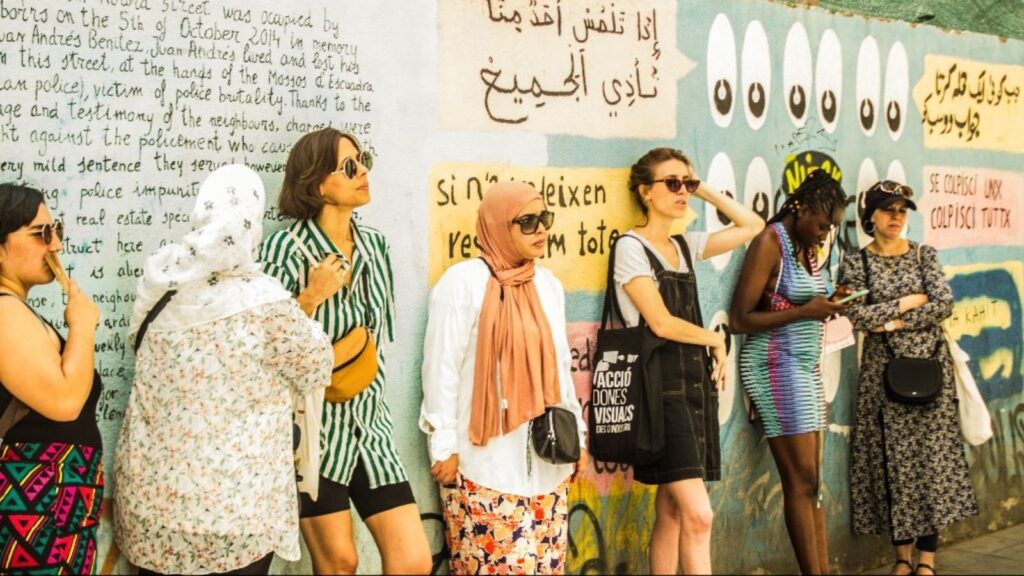 Migrantour group beside a colorful mural on an intercultural walking tour in Barcelona