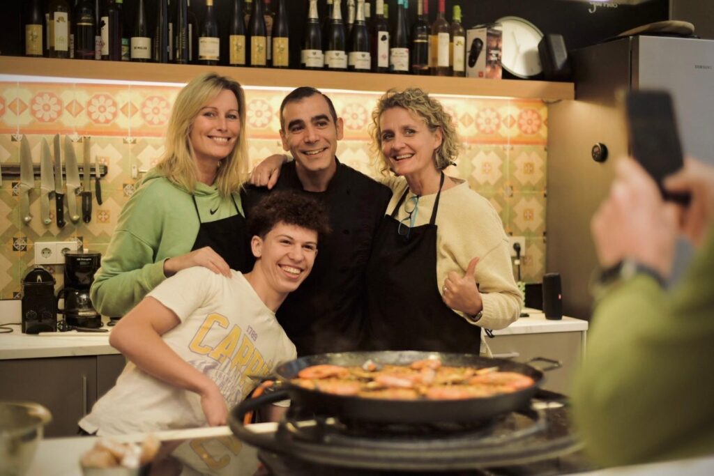 Guests at a Barcelona paella cooking class with the pan in the kitchen