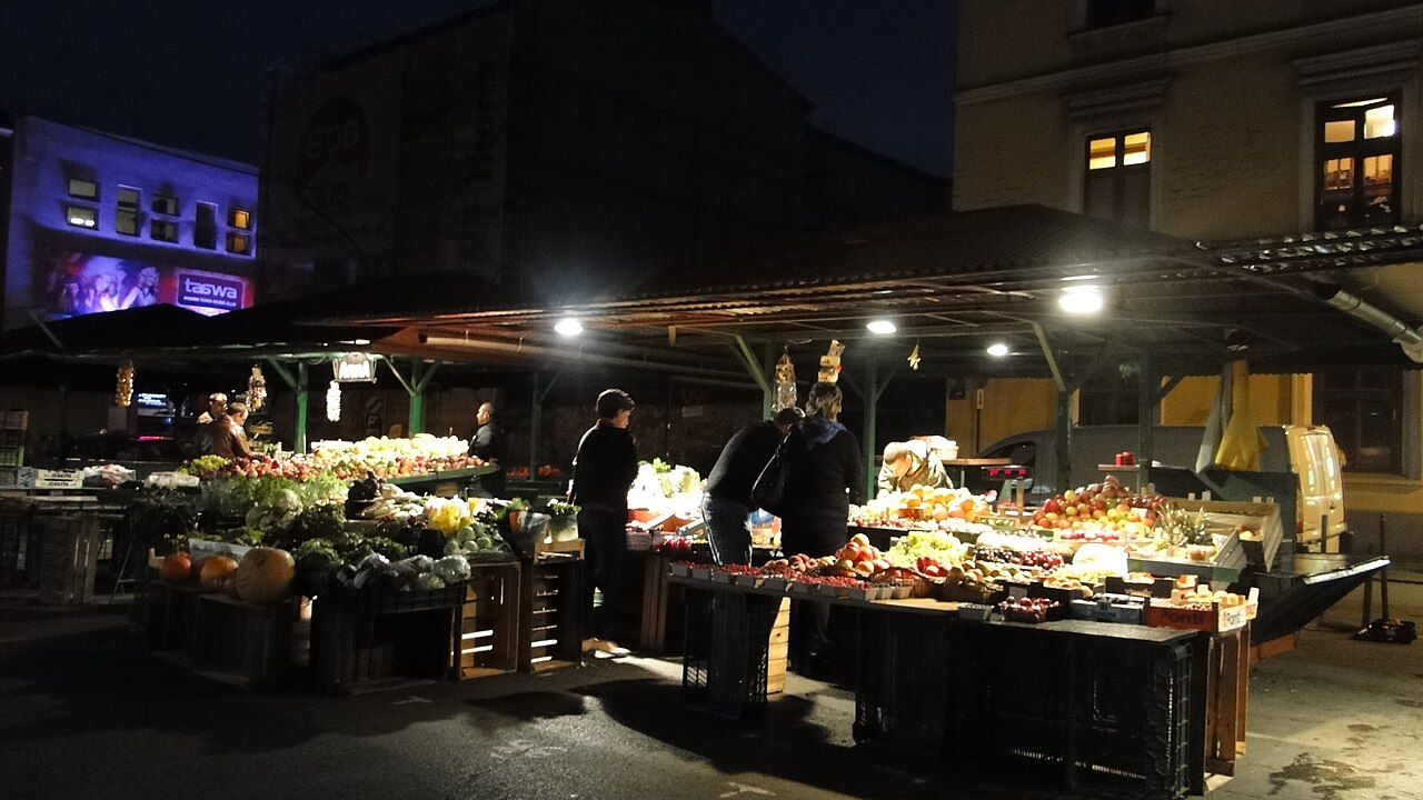 Plac Nowy in Kazimierz, Krakow, lit up at night with market stalls still trading.