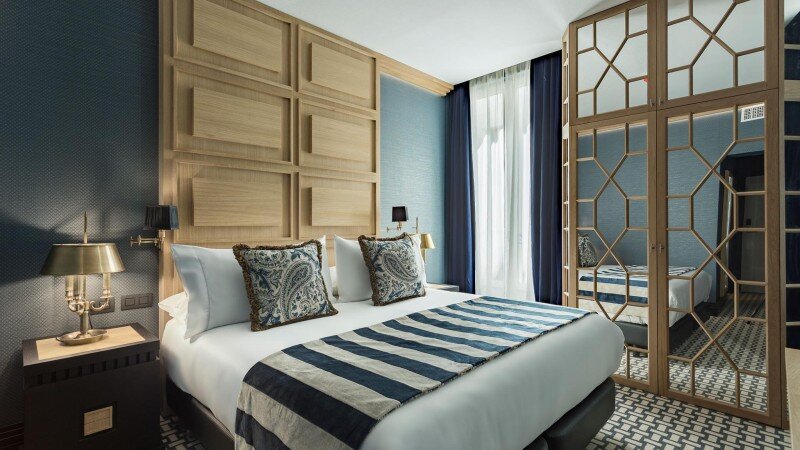 Bright standard room with blue and gold decor at Room Mate Alba in Madrid