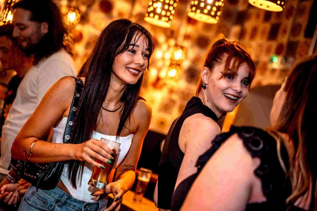 Guests enjoying drinks on a lively Budapest ruin bar crawl at night