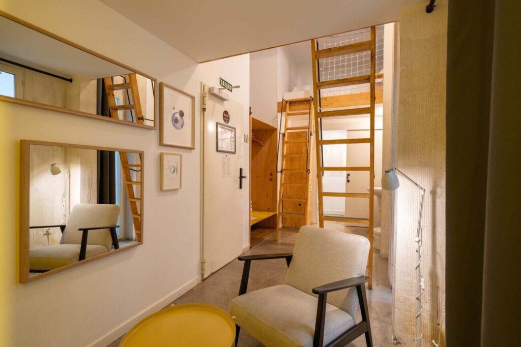 Bright hostel room with bunk ladder at The Hat in Madrid