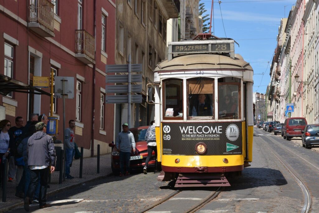 Yellow Tram 28 on a sunny Alfama street in Lisbon